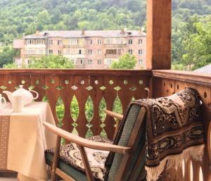 a balcony with a table and a chair and a view of a building at Areguni Cottage in Dilijan
