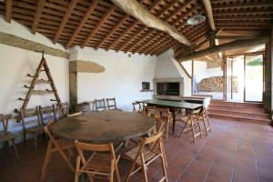 une chambre avec une table, des chaises et une cheminée dans l'établissement Casa rústica con Piscina y finca en Costa da Morte, à Cores