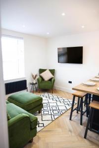 a living room with two green chairs and a television at Skegness Luxury 2 bedroom apartment , sleeps 6 people in Lincolnshire