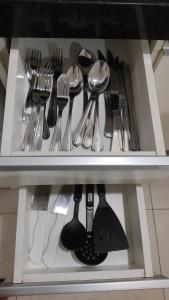 a drawer filled with utensils on a shelf at Apto Central, Conforto Stª Helena, 5min do Centro in Juiz de Fora