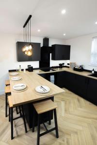 a kitchen with a wooden table with chairs and a counter at Skegness Luxury 2 bedroom apartment , sleeps 6 people in Lincolnshire