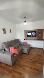 a living room with a couch and a flat screen tv at Apto Central, Conforto Stª Helena, 5min do Centro in Juiz de Fora