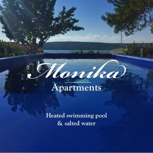 een bord met nominia appartementen verwarmd zwembad en verhoogd water bij Apartments Monika Bed & Breakfast in Punat