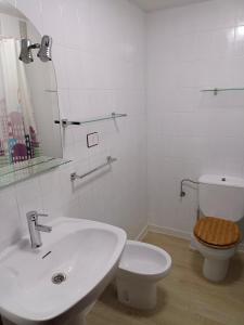 a white bathroom with a toilet and a sink at PONIENTE in Gijón