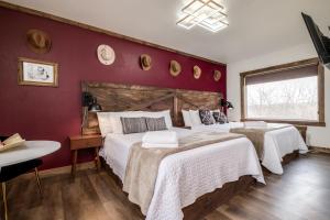 1 dormitorio con 2 camas y pared roja en The Harbor Hotel Chic, Retro Hotel en Prescott