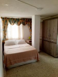 a bedroom with a large bed and a window at Cali Sur Centrar Apto 2 - Somos Pet Friendly in Cali