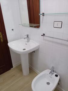 a white bathroom with a sink and a toilet at PONIENTE in Gijón