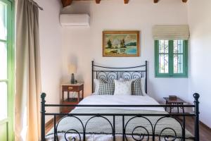 a bedroom with a black bed with pillows at Traditional Farm House in Ermioni
