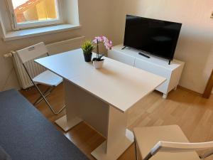 een woonkamer met een witte tafel en een tv bij Privatzimmer im Herzen von Iphofen in Iphofen