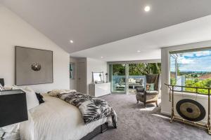 a bedroom with a large bed and a balcony at Artistic Mount Vic Villa in Auckland