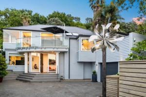 a house with a palm tree in front of it at Artistic Mount Vic Villa in Auckland