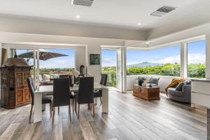 a dining room with a table and chairs and a couch at Artistic Mount Vic Villa in Auckland