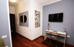 Una habitación con un escritorio y un televisor en la pared. en Isonzo Home, en Cosenza