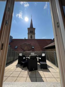 een balkon met een tafel, een parasol en een kerk bij Privatzimmer im Herzen von Iphofen in Iphofen