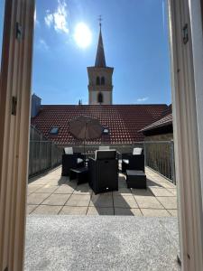 een uitzicht op een kerk met een tafel en een paraplu bij Privatzimmer im Herzen von Iphofen in Iphofen