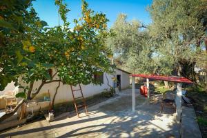 an orange tree with a red canopy and a swing at Friends Villa in Sarandë