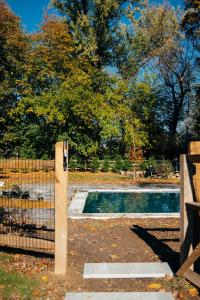 een hek naast een zwembad in een tuin bij Serene Estate - Heated Saltwater Pool, Sauna, 5 Mins to Hudson in Catskill