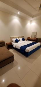 a bedroom with a large bed and a couch at المبيت 4 للشقق الفندقيه in Hajlah