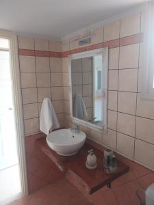 een badkamer met een wastafel en een spiegel bij Vivi's Apartments Loft in Spetses