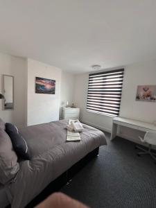 a bedroom with a bed and a desk and a window at 3 bed house in Leicester! in Leicester