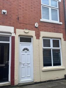 a brick building with a white door and two windows at 3 bed house in Leicester! in Leicester