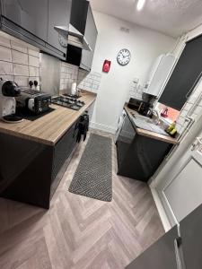 a kitchen with a counter and a clock on the wall at 3 bed house in Leicester! in Leicester
