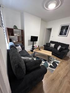 a living room with two couches and a coffee table at 3 bed house in Leicester! in Leicester