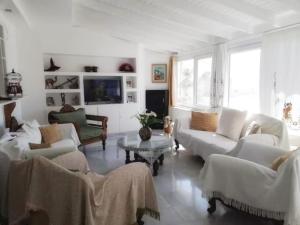 a white living room with couches and a table at Vaso' s Home in Koropíon