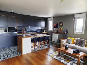 a kitchen and living room with a couch and a table at Magnifique appartement avec terrasse et parking, 8 Personnes in Nanterre