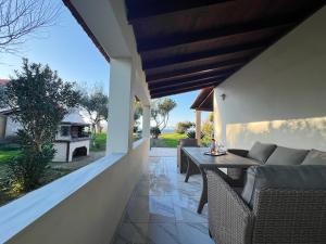 a patio with a couch and a table on a house at Dimitra Houses 3 - Seaside in Lefkimmi