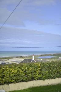 un phare au-dessus d'une maison avec l'océan dans l'établissement Le Cottage de la Baie - vue mer en Baie de Somme, à Woignarue 25 autres photos
