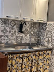 encimera de cocina con fregadero y azulejos en la pared en Casinha Vilarejo, en Cabo Frío