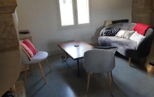 sala de estar con sofá, mesa y sillas en Maison de charme avec bassin de nage 