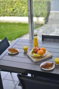 une table avec une assiette de fruits et de jus d'orange dans l'établissement Le Cottage de la Baie - vue mer en Baie de Somme, à Woignarue