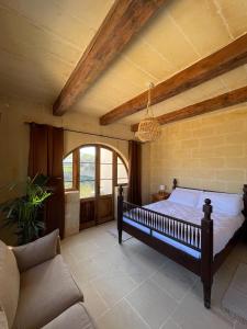 1 dormitorio con 1 cama y 1 sofá en Soluna Boutique Guesthouse, en Għasri