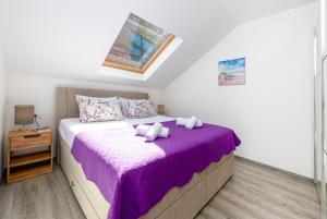 a bedroom with a bed with a purple blanket at Peaceful apartment near the beach - Sole in Zaton