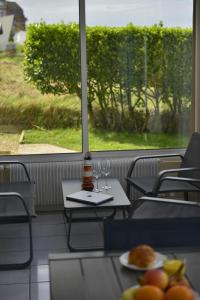 a table with two glasses and a plate of food at Le Cottage de la Baie - vue mer en Baie de Somme in Woignarue