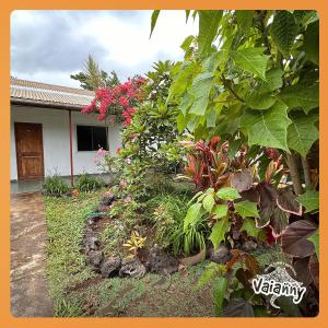 a garden in front of a house with flowers at Hostal Vaianny in Hanga Roa