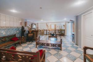 a living room with benches and a table in a room at Pousada Cidreira in Morretes