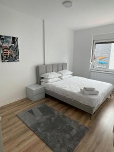 um quarto branco com uma cama e um tapete em Apartment Prishtina 038 em Pristina
