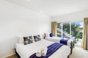 2 camas en una habitación con ventana en Sensational Rest in the North, en Auckland