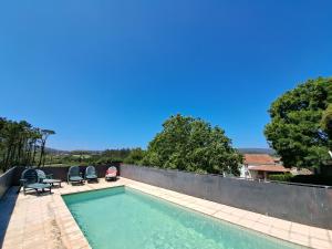una piscina con 2 sillas junto a una valla en Casa rústica con Piscina y finca en Costa da Morte en Cores