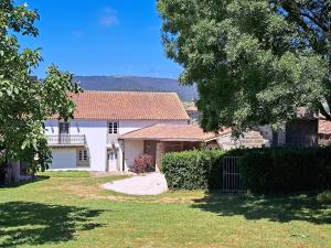 una casa blanca con un árbol y una entrada en Casa rústica con Piscina y finca en Costa da Morte en Cores