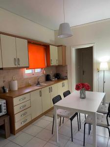 a kitchen with a white table and chairs and a table and a table at Nav Apart, Salamina in Paloúkia