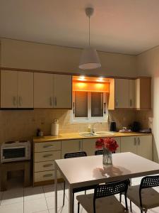 a kitchen with a table and a table and chairs at Nav Apart, Salamina in Paloúkia +13 photos