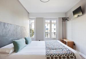 a bedroom with a large white bed and a window at PR 25 de Julio in Santiago de Compostela