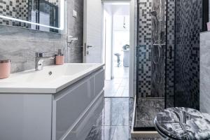 a bathroom with a sink and a shower at Peaceful apartment near the beach - Sole in Zaton +21 photos