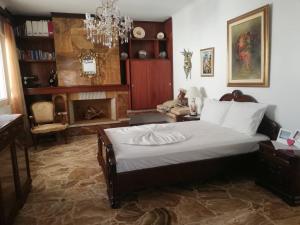a bedroom with a large bed and a chandelier at Vaso' s Home in Koropíon