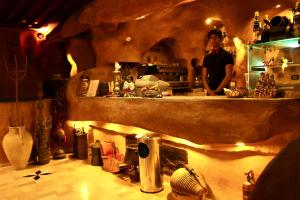 a man standing behind a counter in a restaurant kitchen at Hotel DONIA in Hammam-Plage