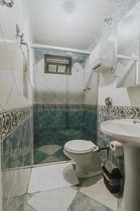 a bathroom with a shower and a toilet and a sink at Pousada Cidreira in Morretes